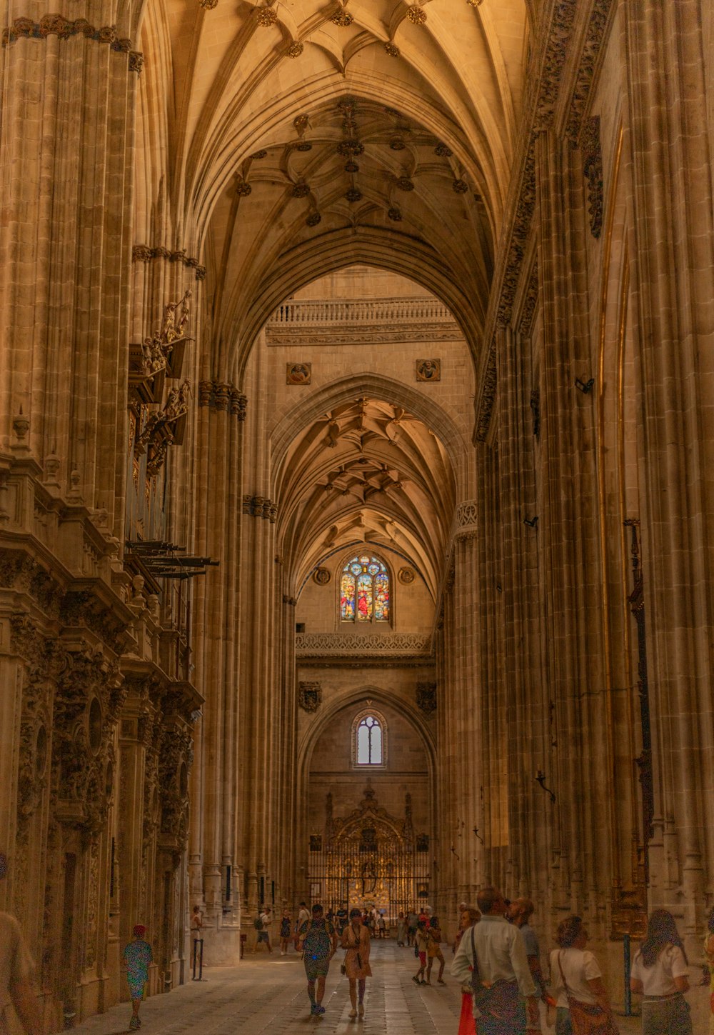 a group of people walking through a large cathedral