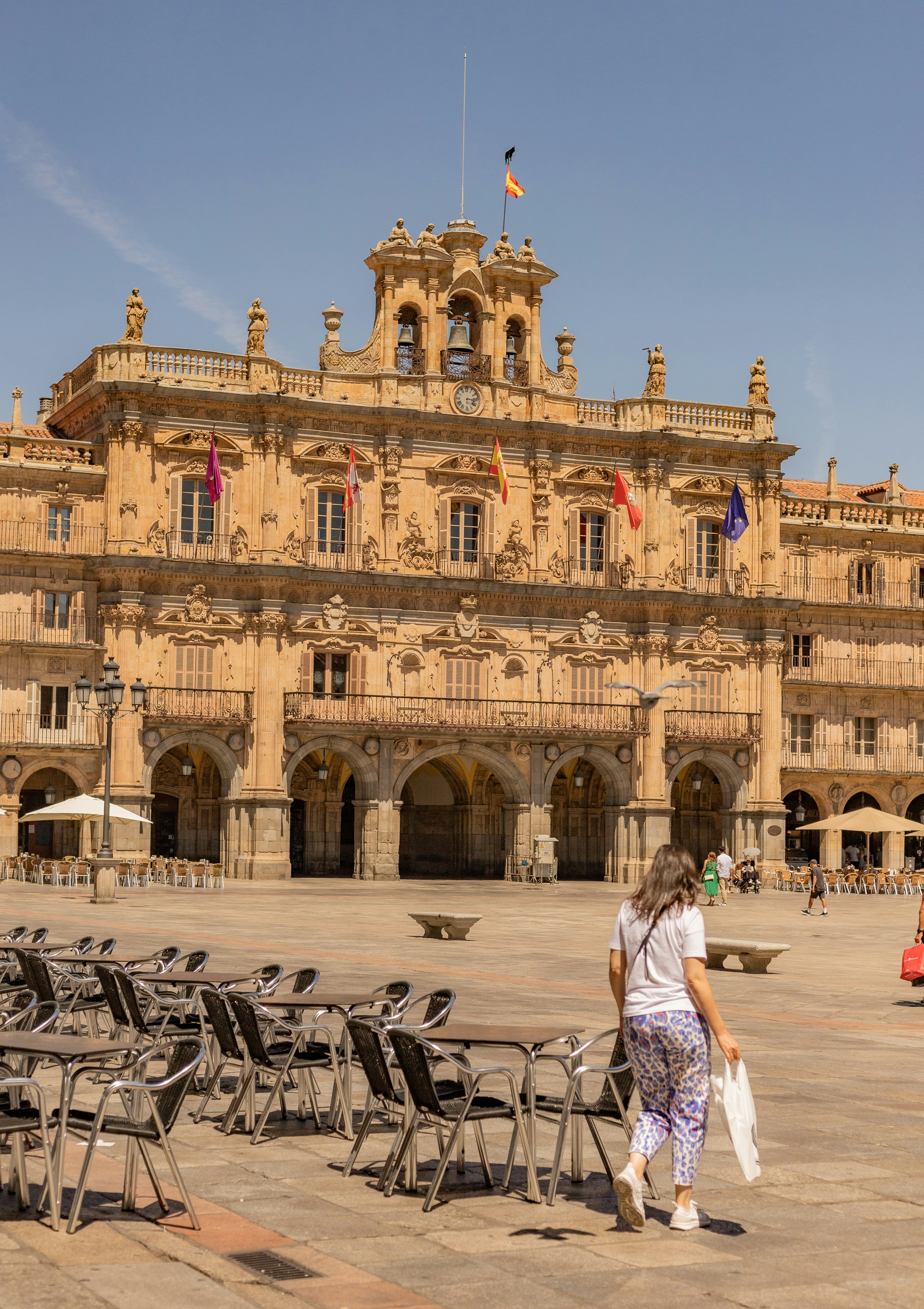 a woman is walking in front of a large building