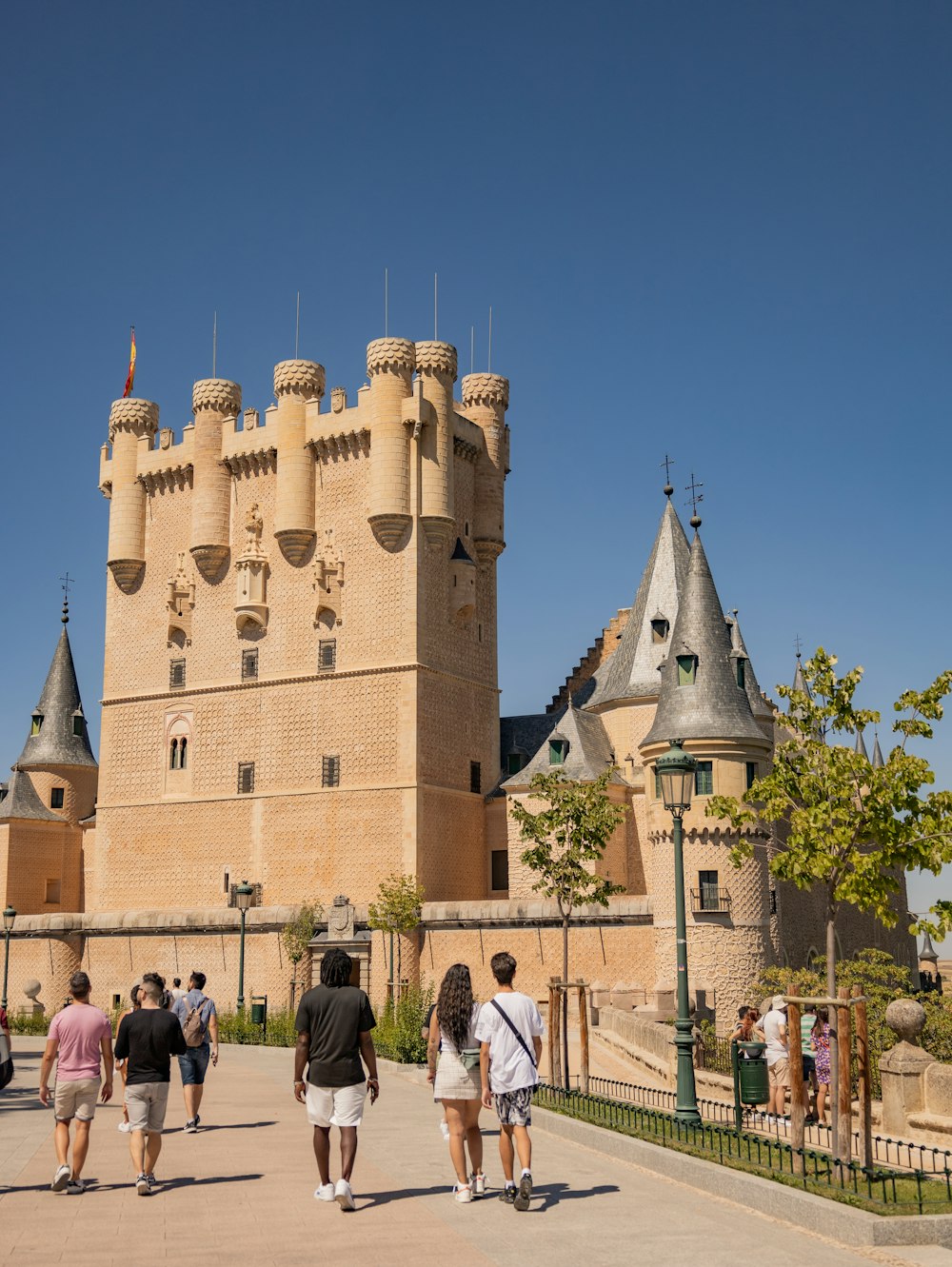 a group of people walking in front of a castle