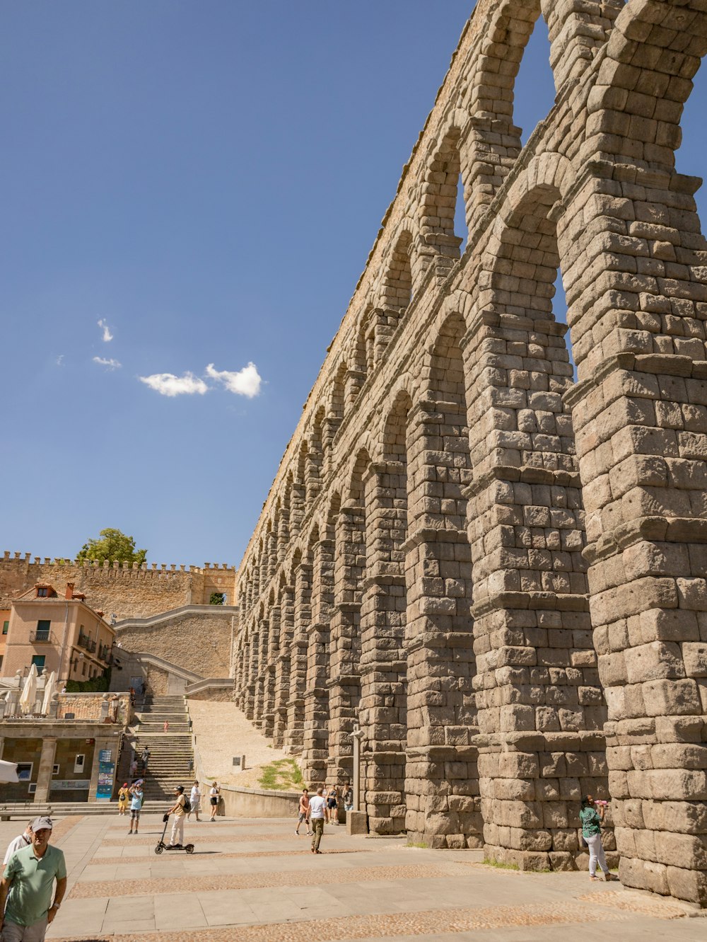 a large stone structure with people walking around it