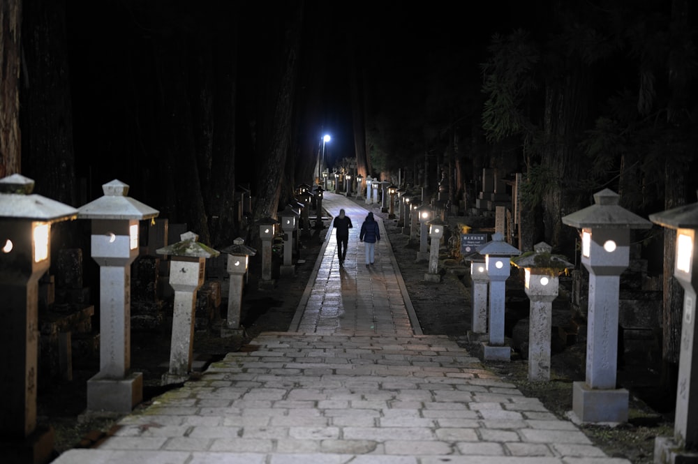 two people walking down a path at night