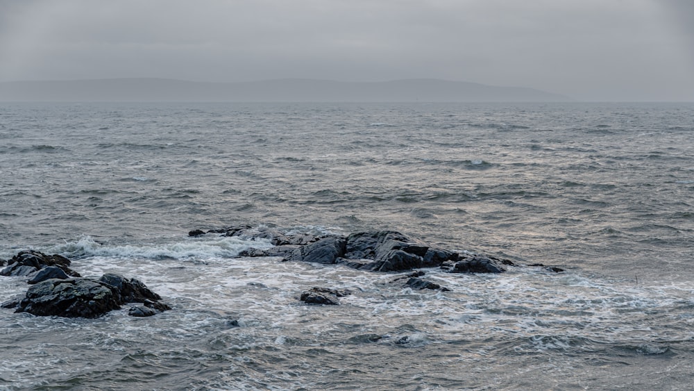 a large body of water sitting next to a rocky shore