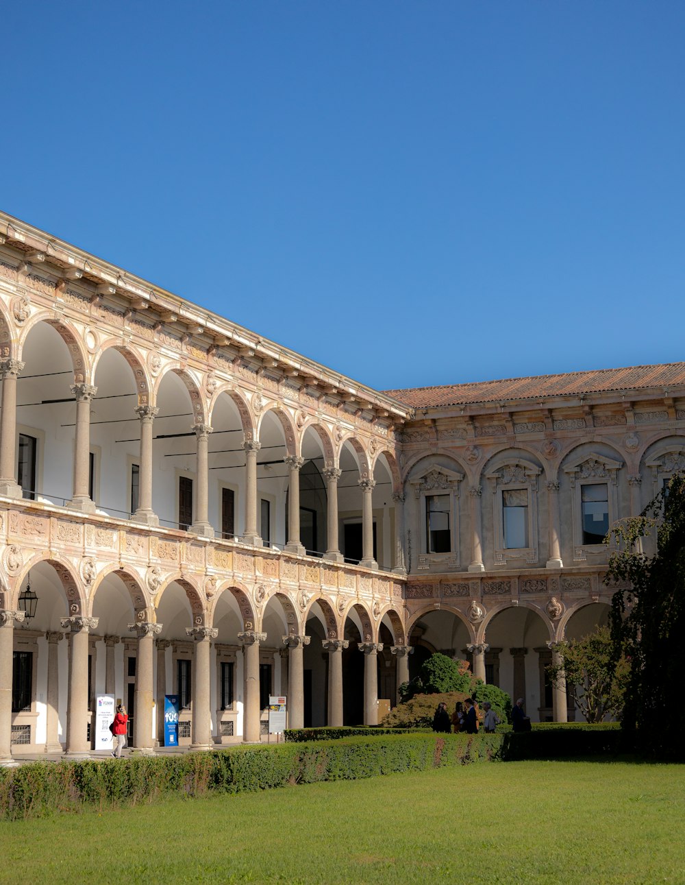 a building with arches and a lawn in front of it