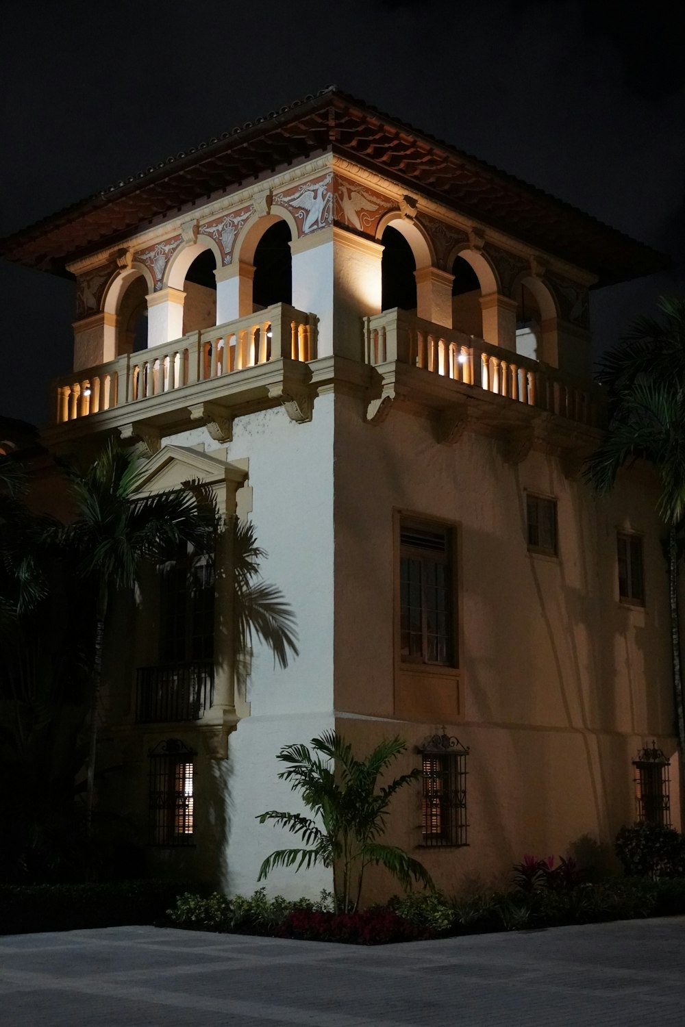 Un edificio alto con balcón y balcones iluminados por la noche