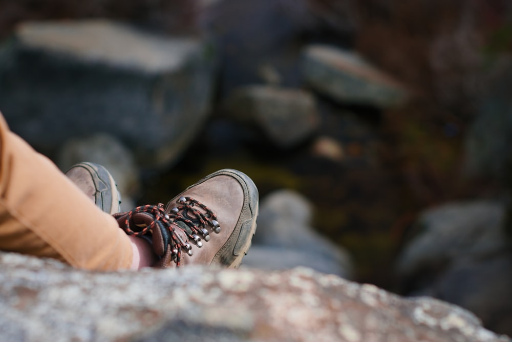 a person sitting on top of a large rock