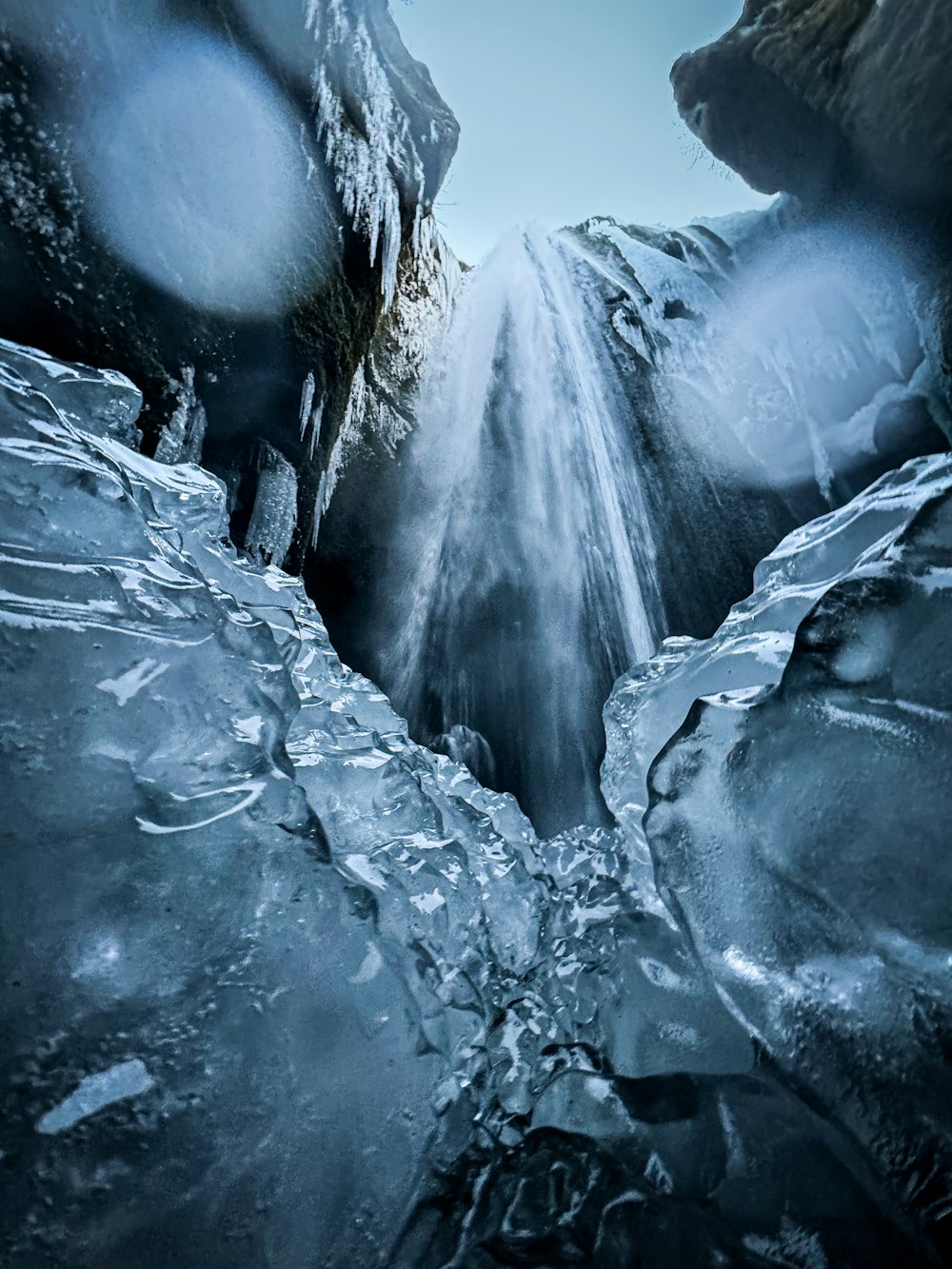 a frozen waterfall in the middle of a forest