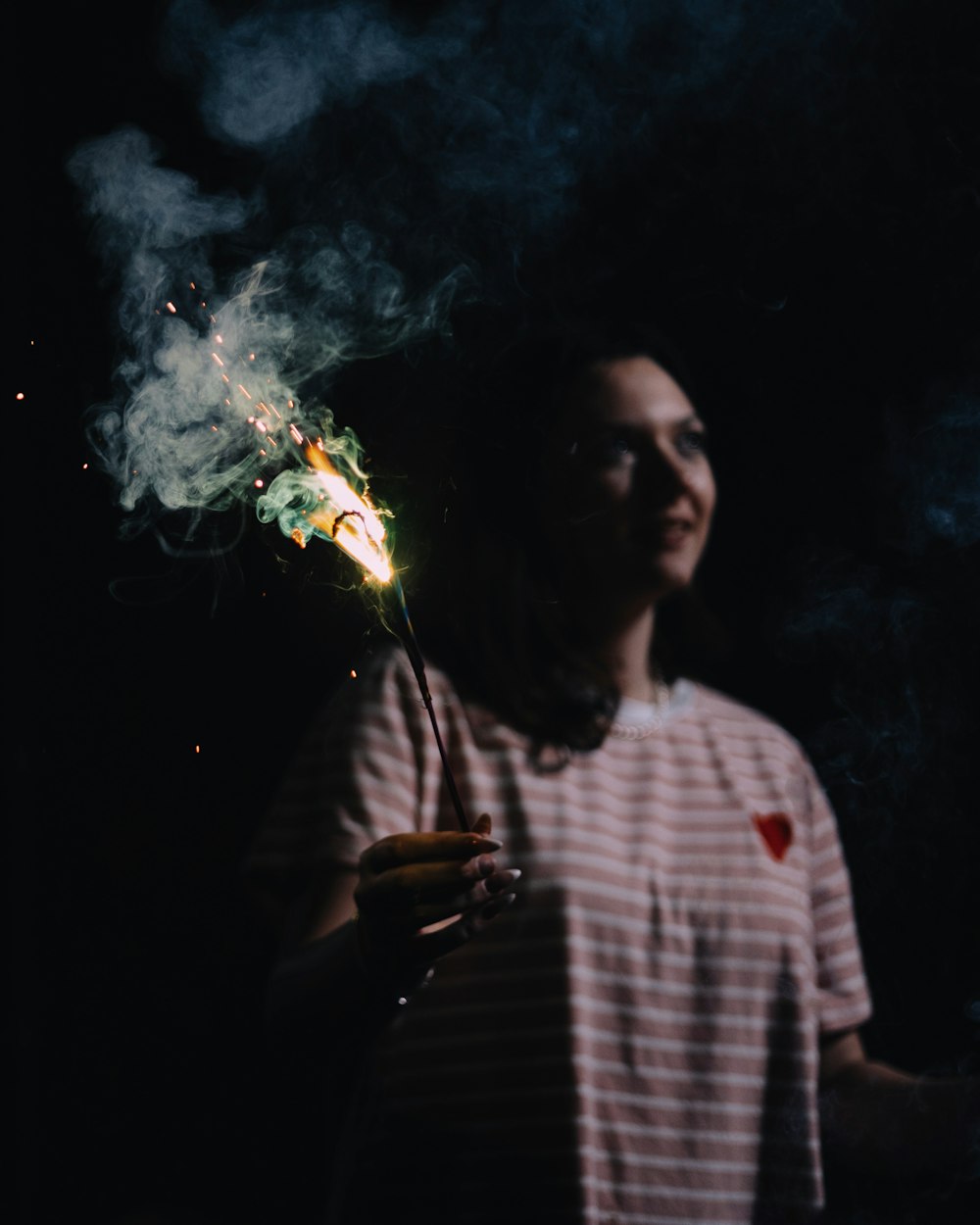 a man holding a lit sparkler in his hand