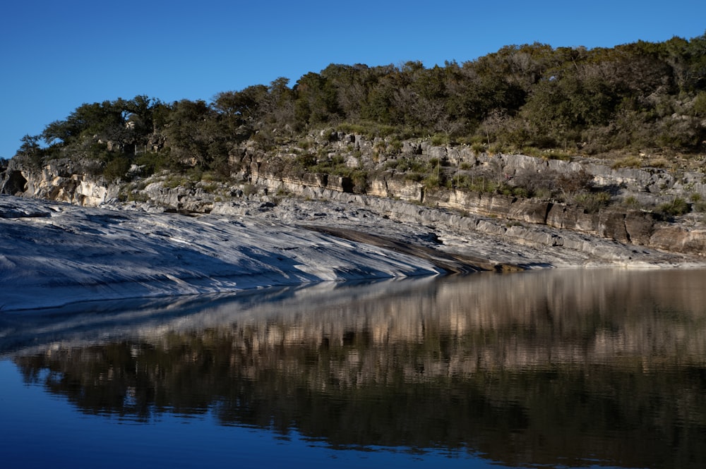 a body of water with a mountain in the background