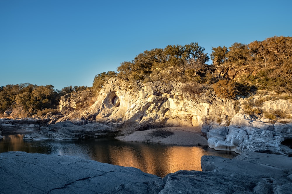 a body of water surrounded by rocks and trees