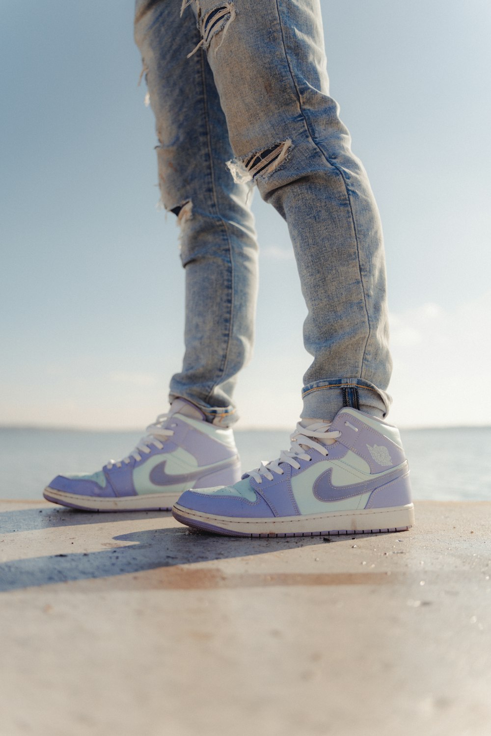 a person standing on a beach with their legs crossed