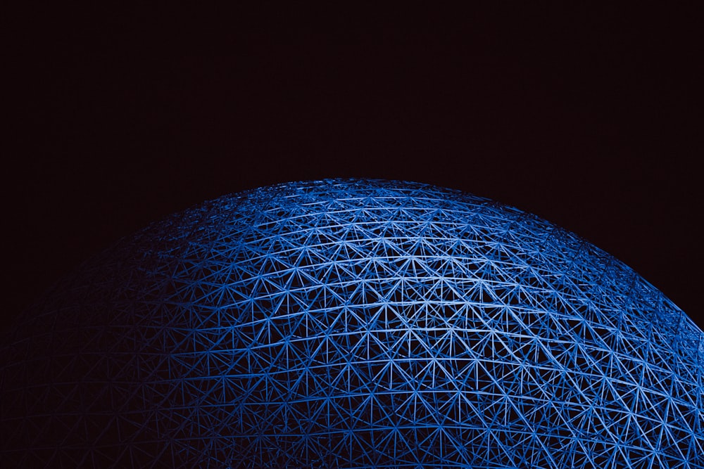 Una grande struttura blu è illuminata al buio