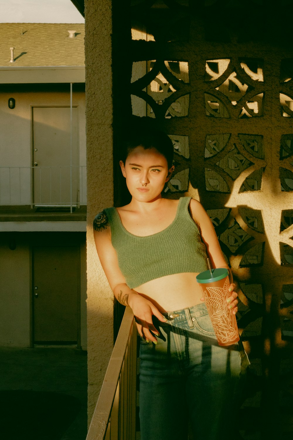 a woman standing on a balcony holding a skateboard