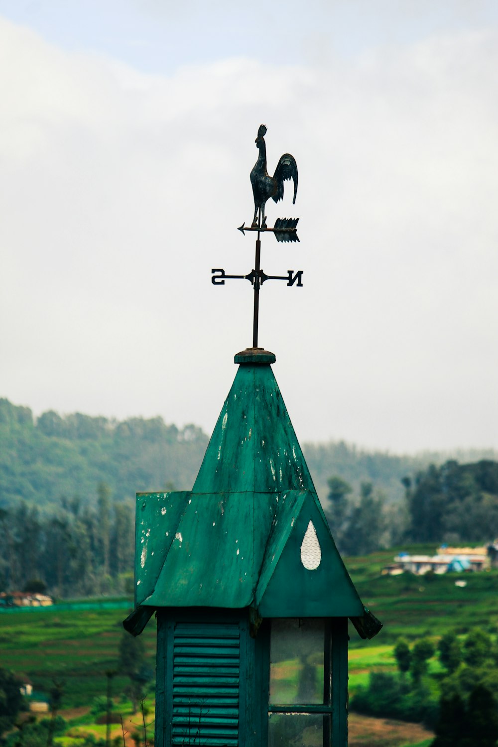 a weather vane on top of a green building