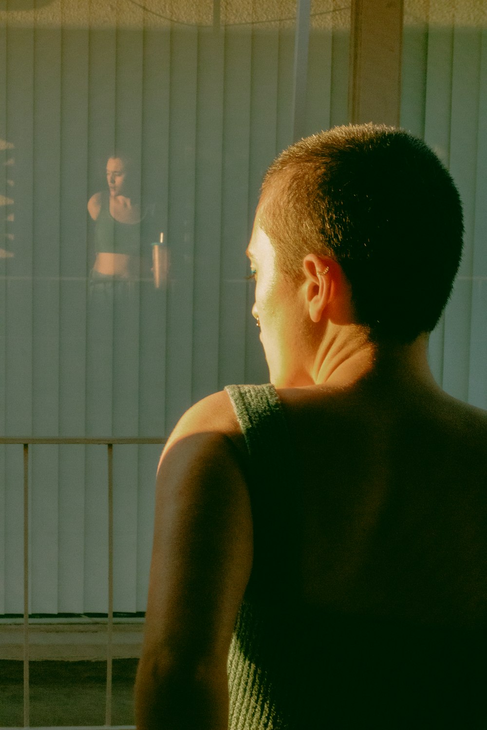 a man standing in front of a window next to a woman
