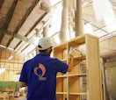 a man in a blue shirt and white hat working on a shelf