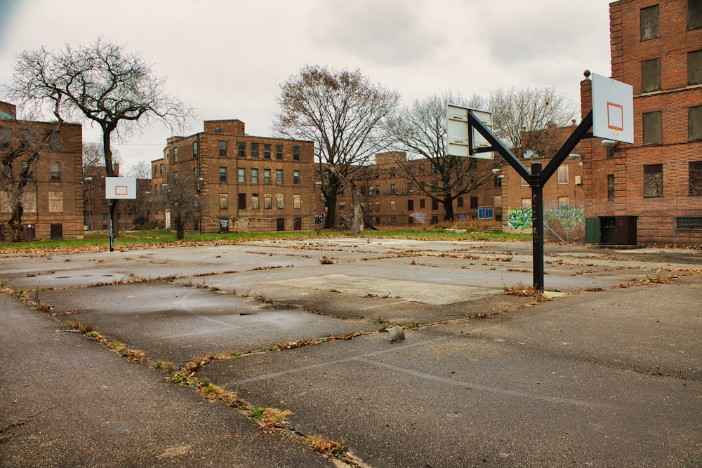 an empty basketball court surrounded by brick buildings