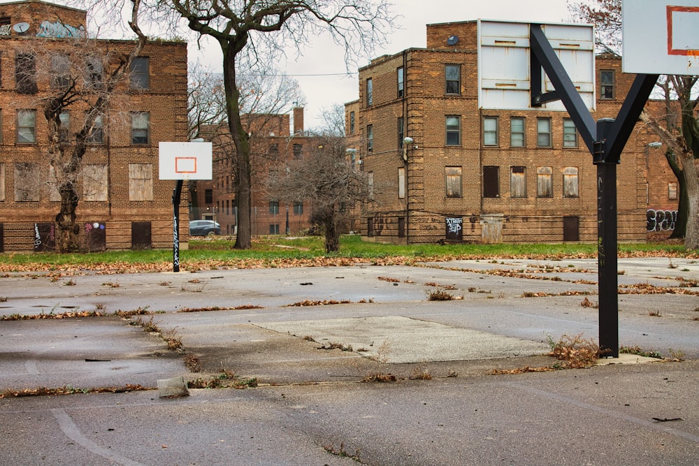 an empty basketball court in front of a brick building