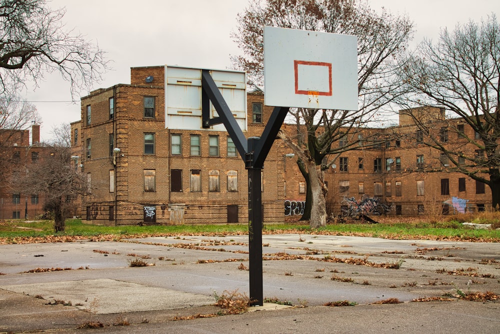 煉瓦造りの建物の前にある空っぽのバスケットボールコート