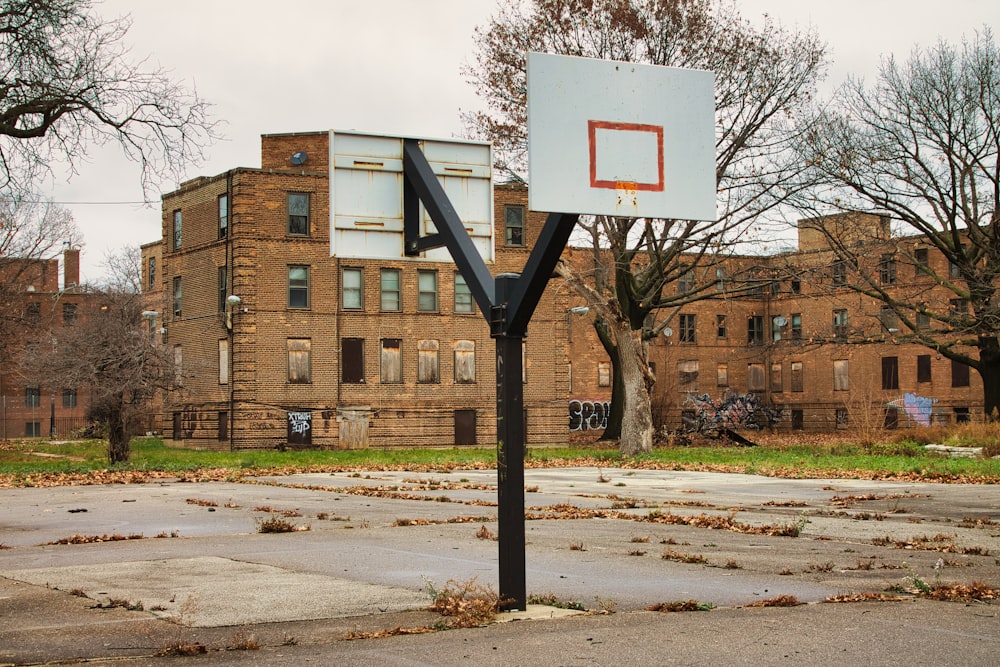 ein leerer Basketballplatz vor einem Backsteingebäude