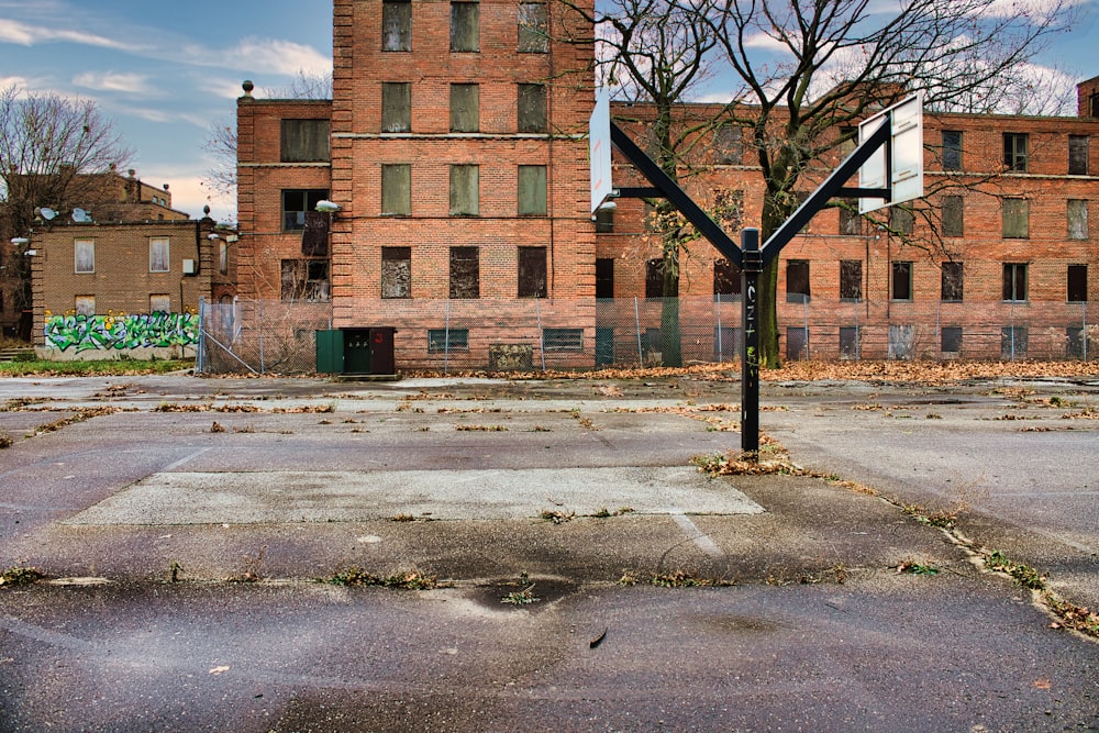 an empty basketball court in front of a brick building