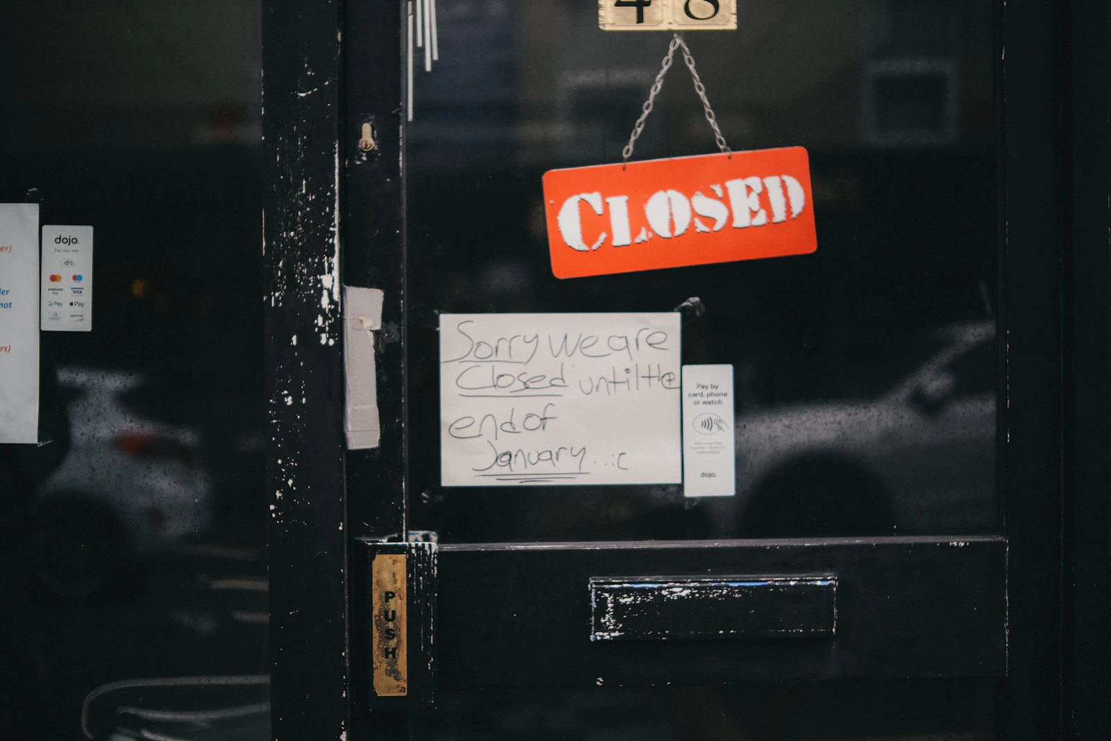 문에 Closed 사인이 걸린 닫힌 상점