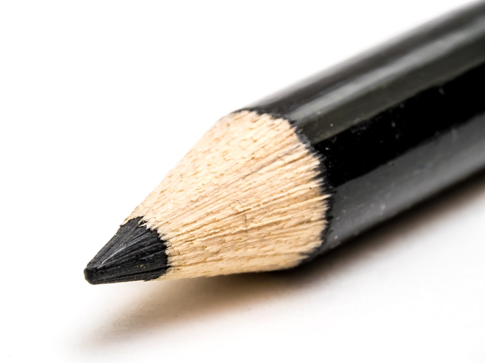 a close up of a pencil on a white surface