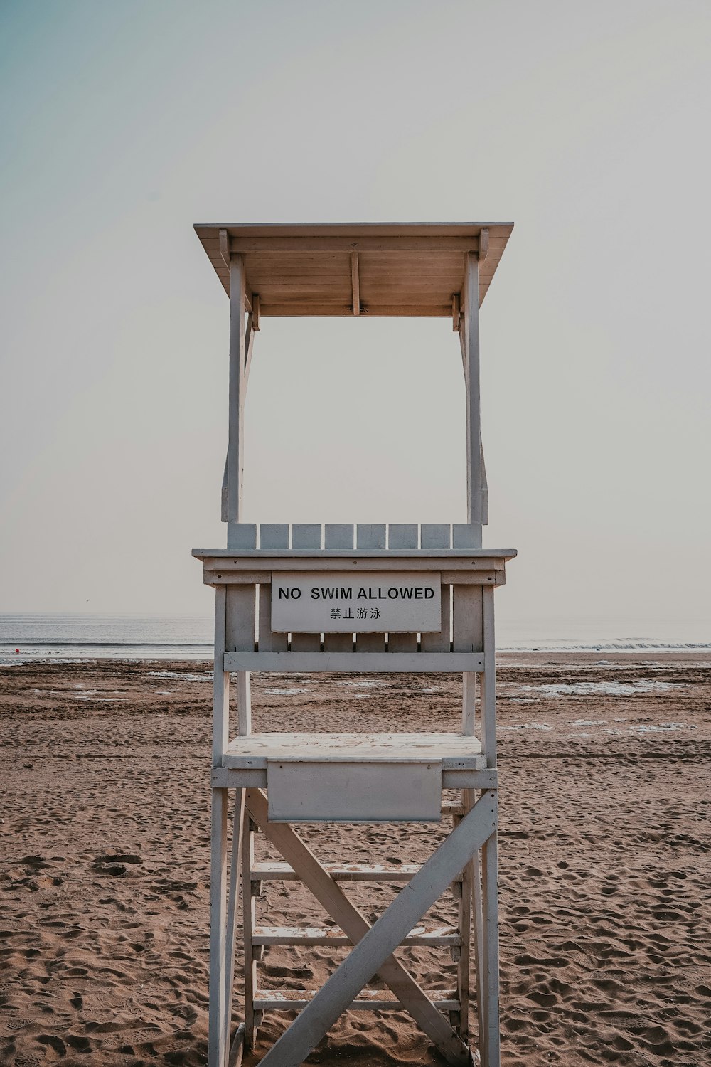 a lifeguard chair sitting on top of a sandy beach