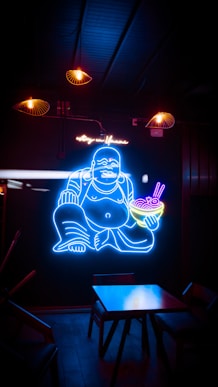 a neon sign of a buddha holding a bowl of food