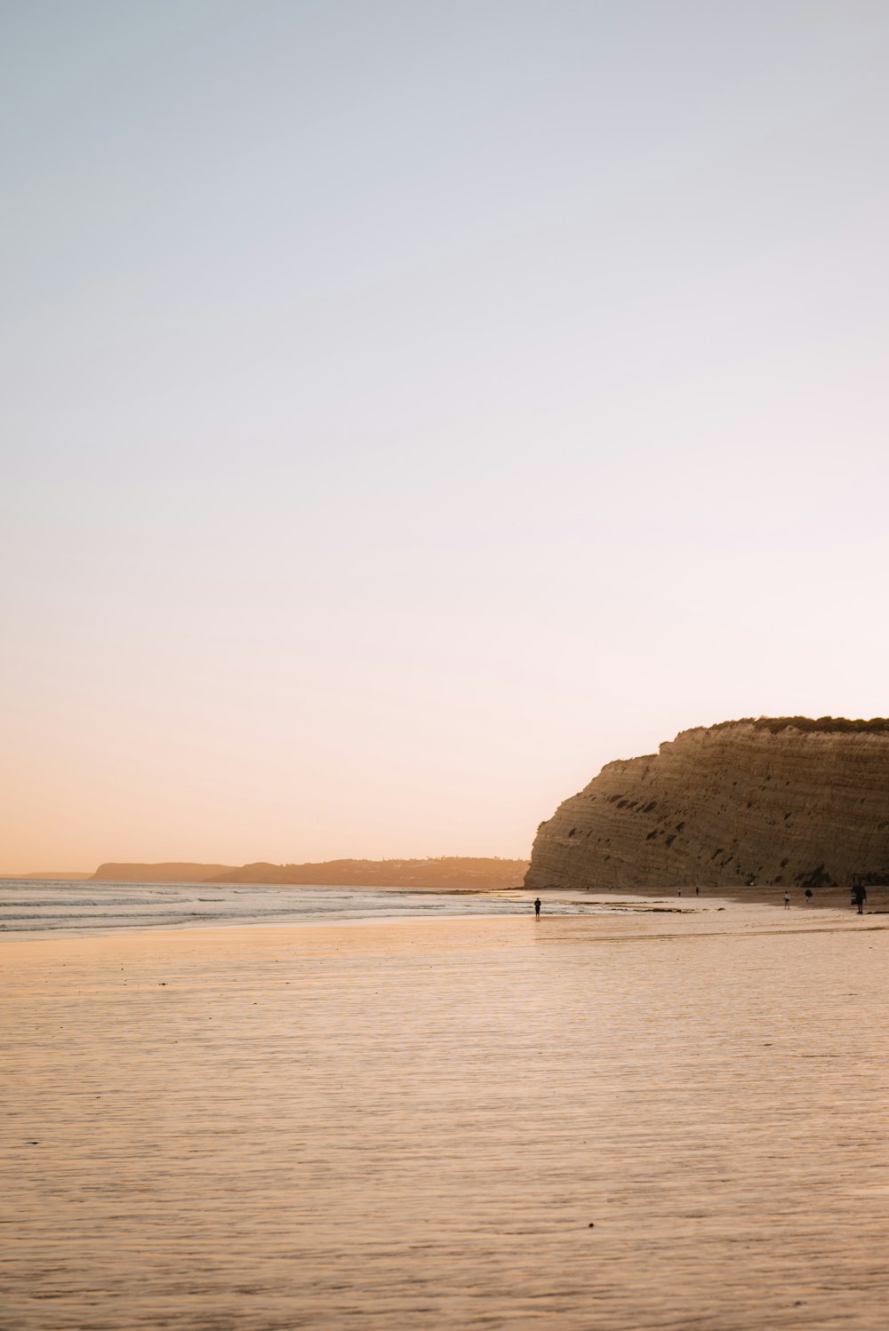 a person walking on a beach with a surfboard