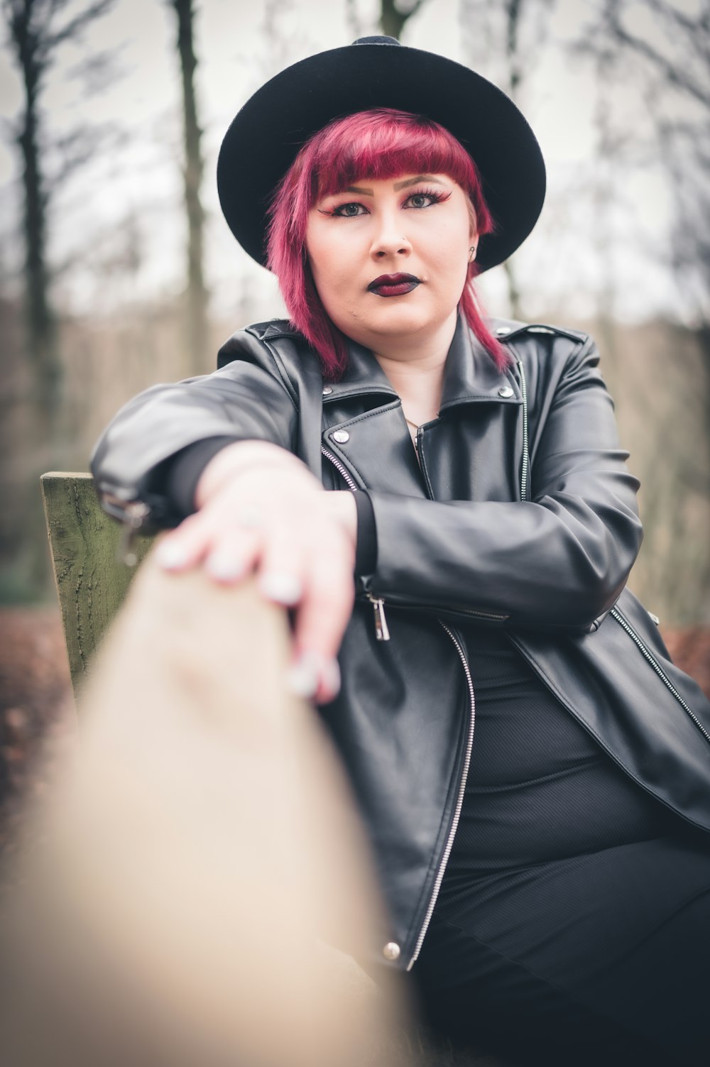 a woman with red hair sitting on a bench