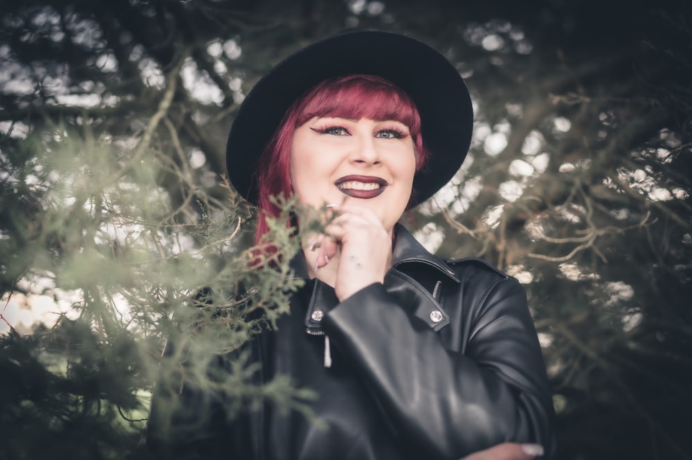 a woman with red hair wearing a black hat