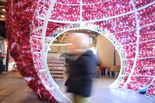 a person walking in front of a red and white sculpture