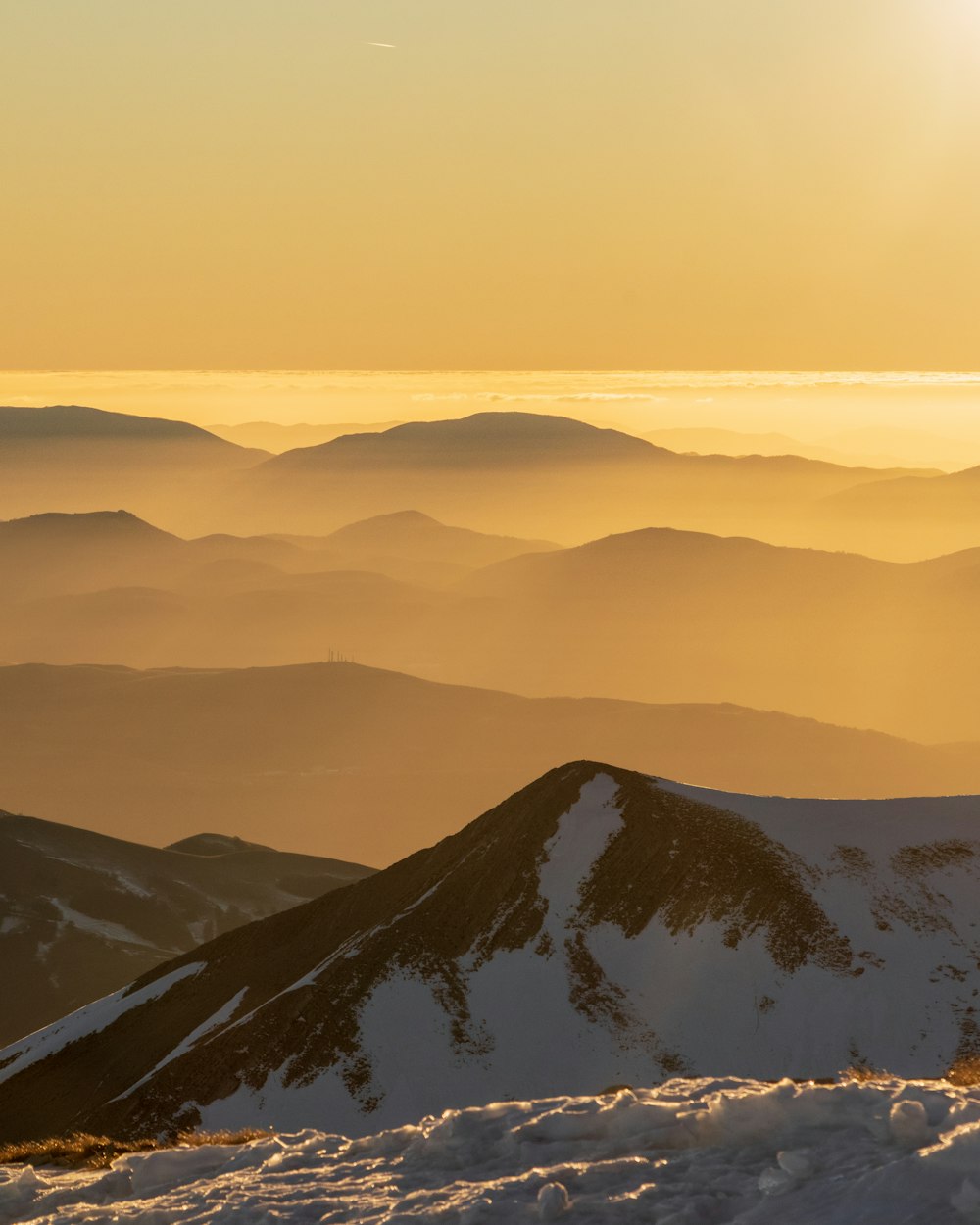 a person standing on top of a snow covered mountain