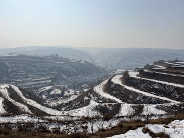 a snow covered landscape with a mountain in the background