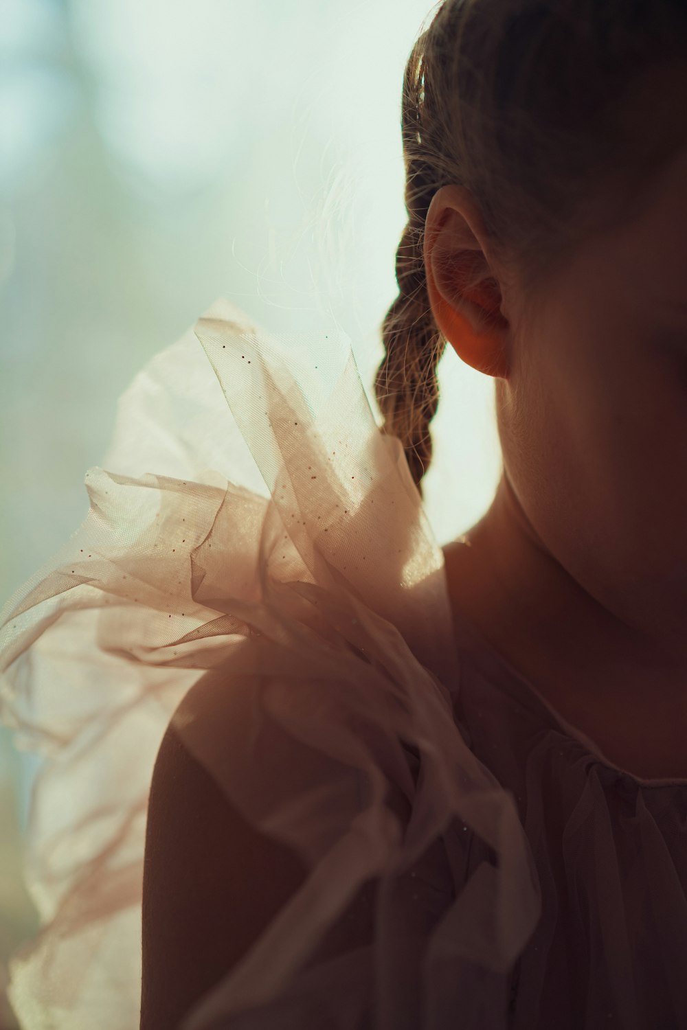 a little girl with a ponytail in a dress