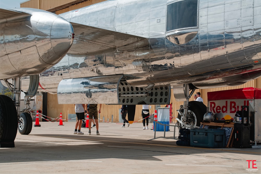 Un grand avion argenté posé sur le tarmac d’un aéroport