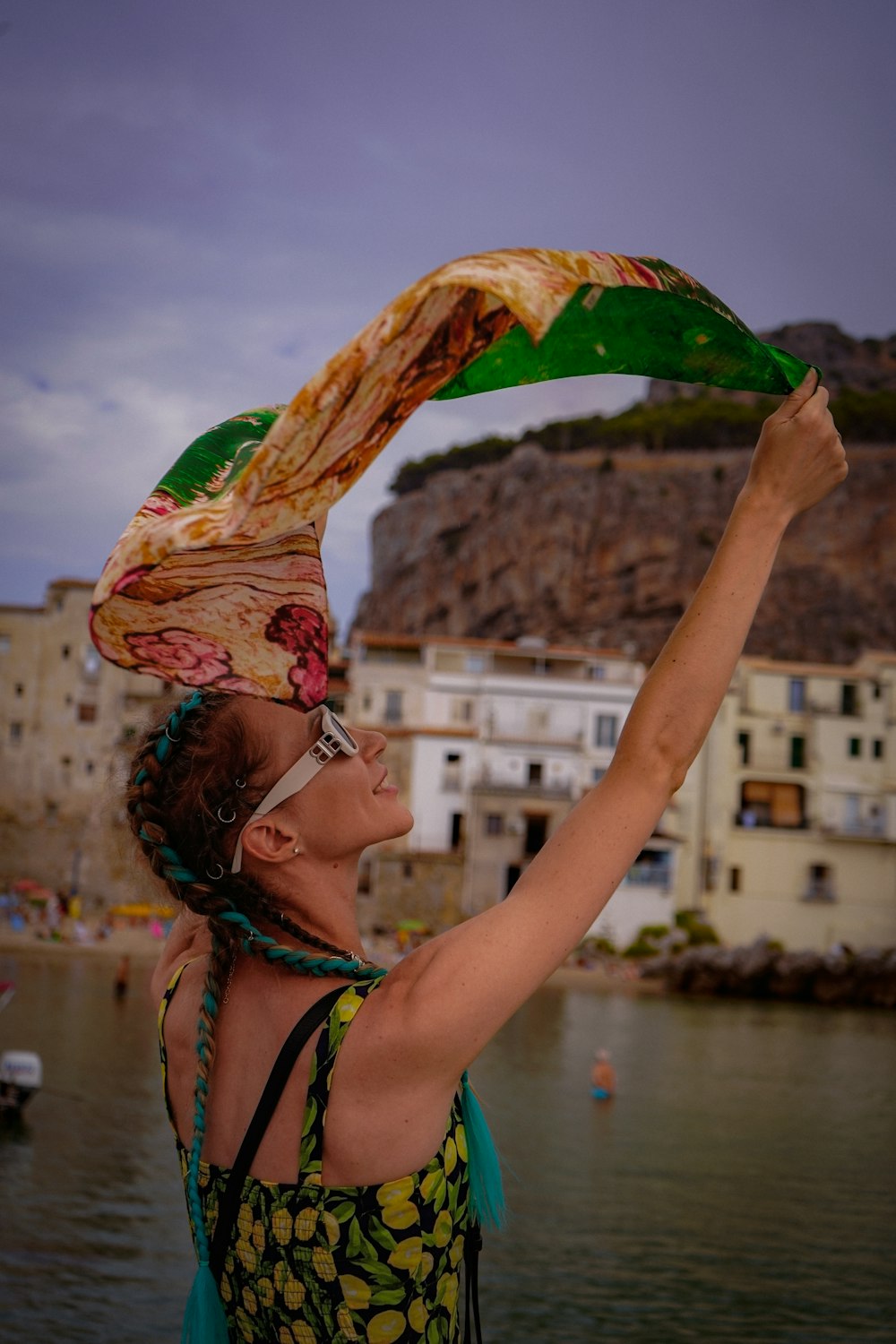 a woman holding a green scarf over her head