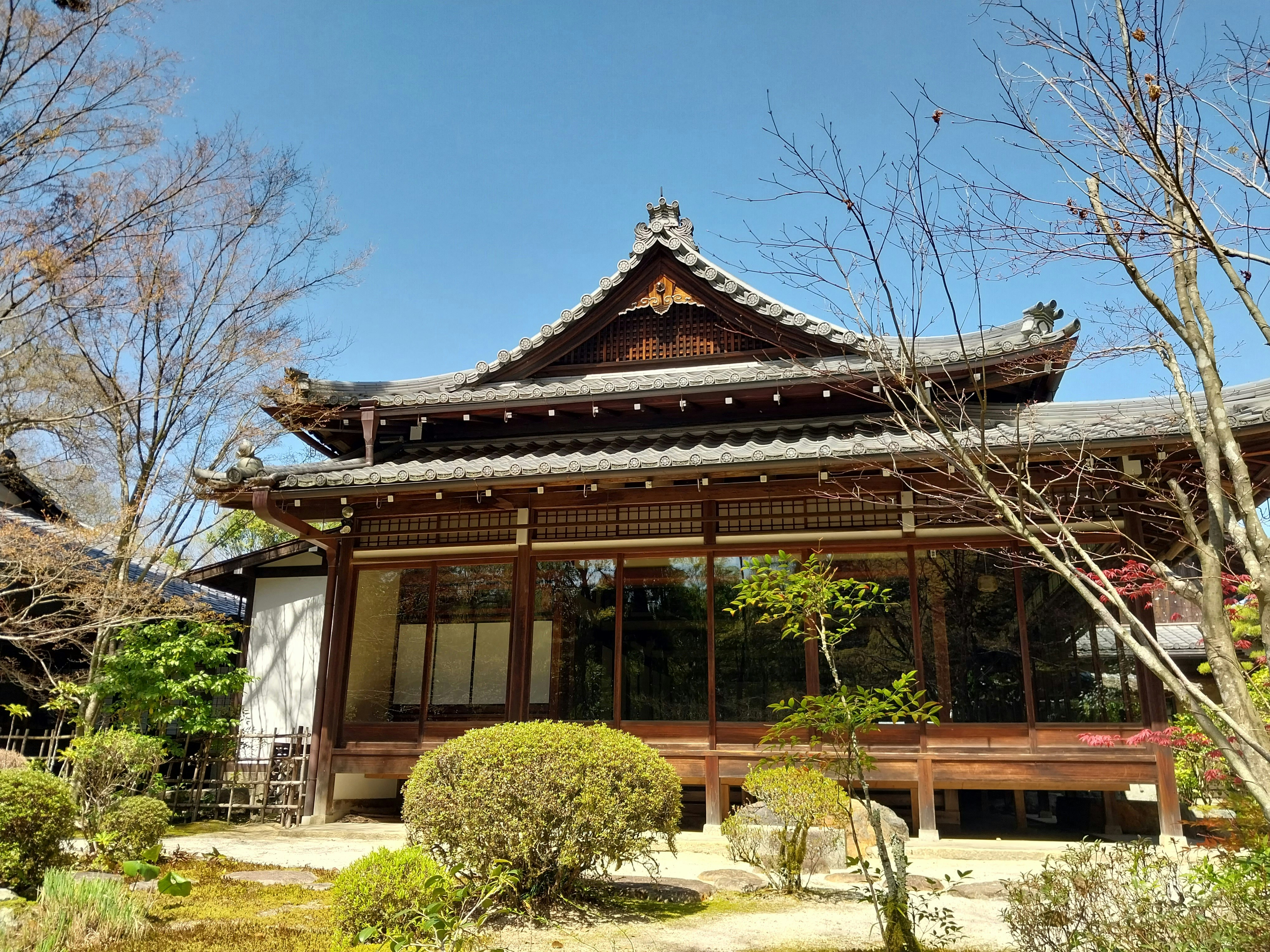 a building with a wooden roof surrounded by trees