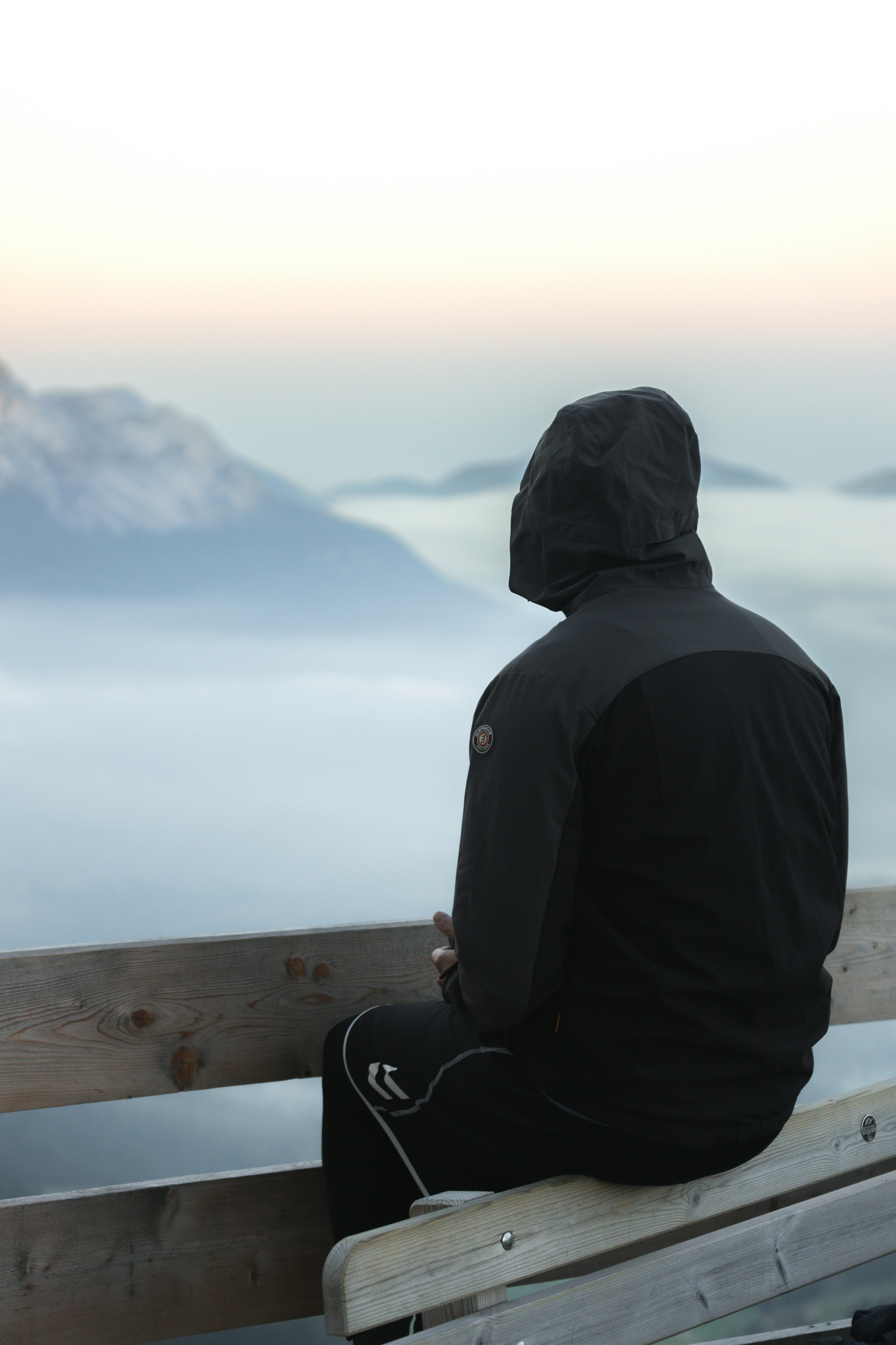 a man sitting on top of a wooden bench