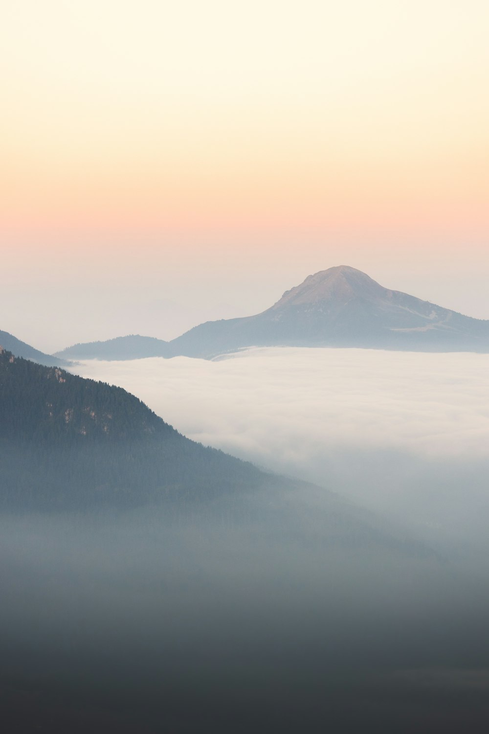 a mountain covered in fog and low lying clouds