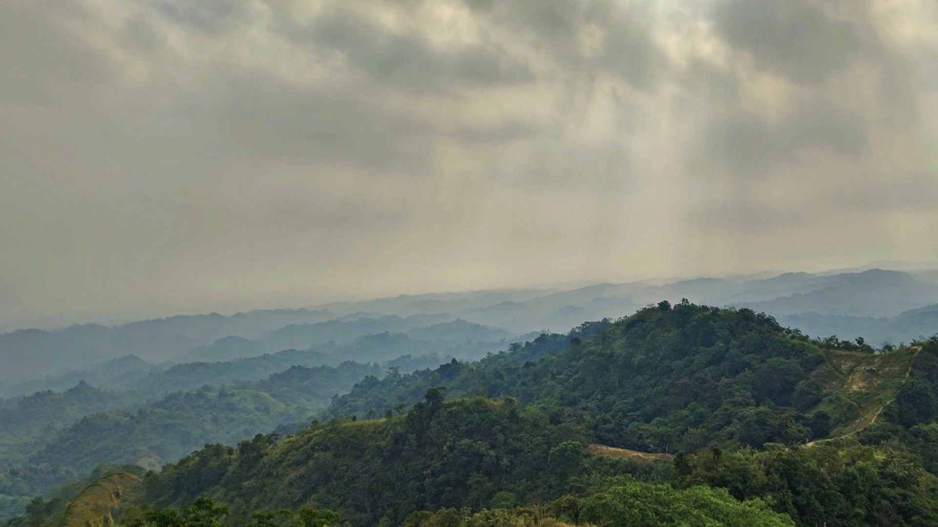 a view of a mountain range with trees and mountains in the background