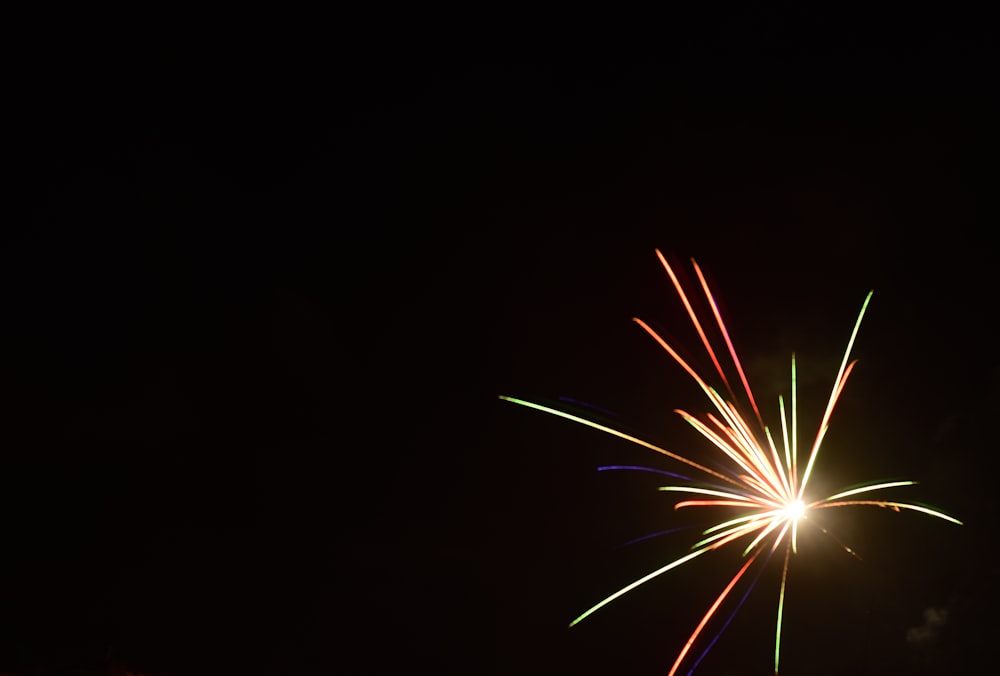 a fireworks is lit up in the dark sky