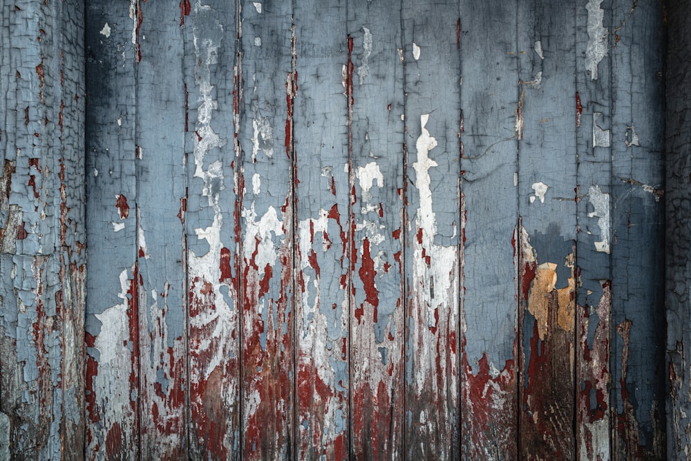 a rusted metal wall with red and white paint