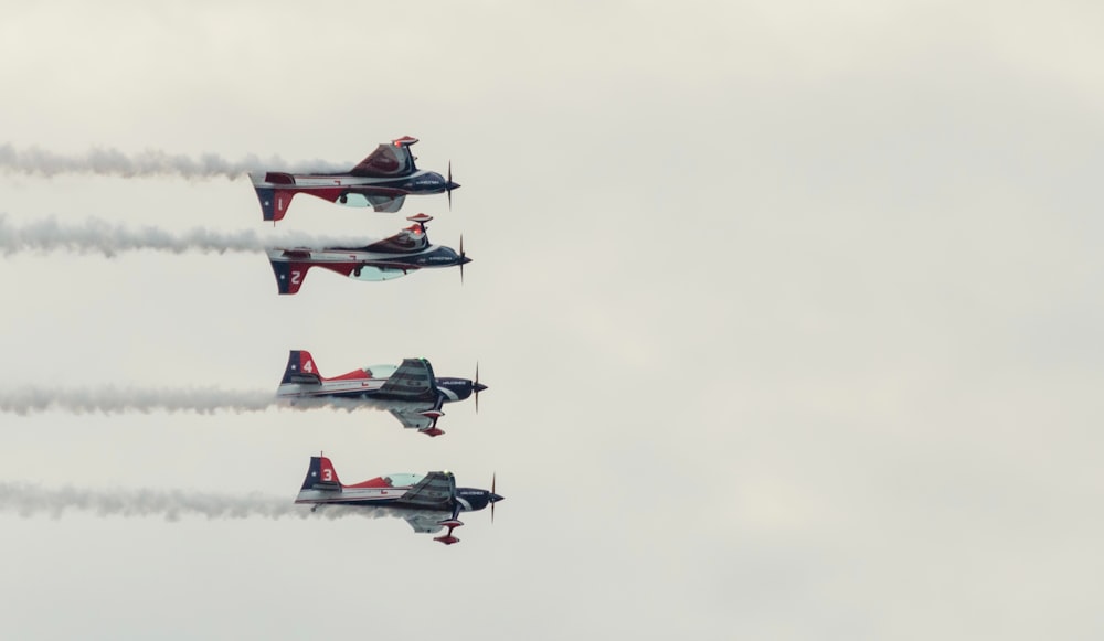 um grupo de aviões voando através de um céu nublado