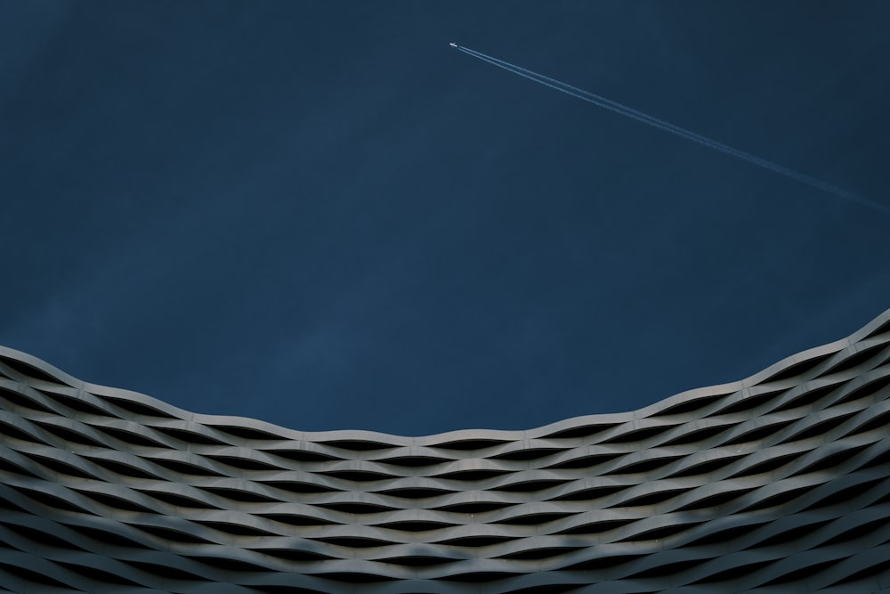 a plane flying in the sky over a building