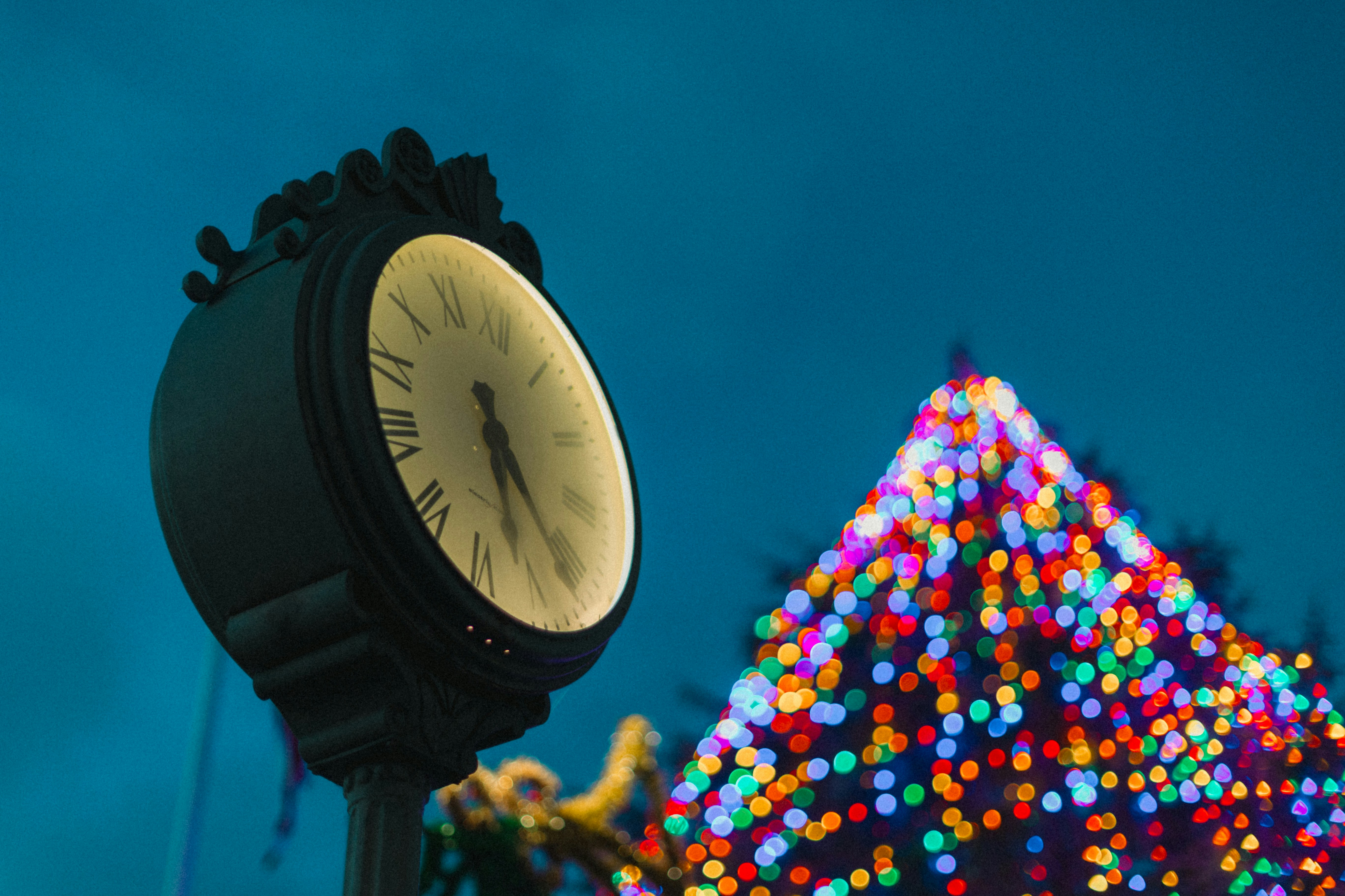 Fotomural a clock on a pole in front of a christmas tree