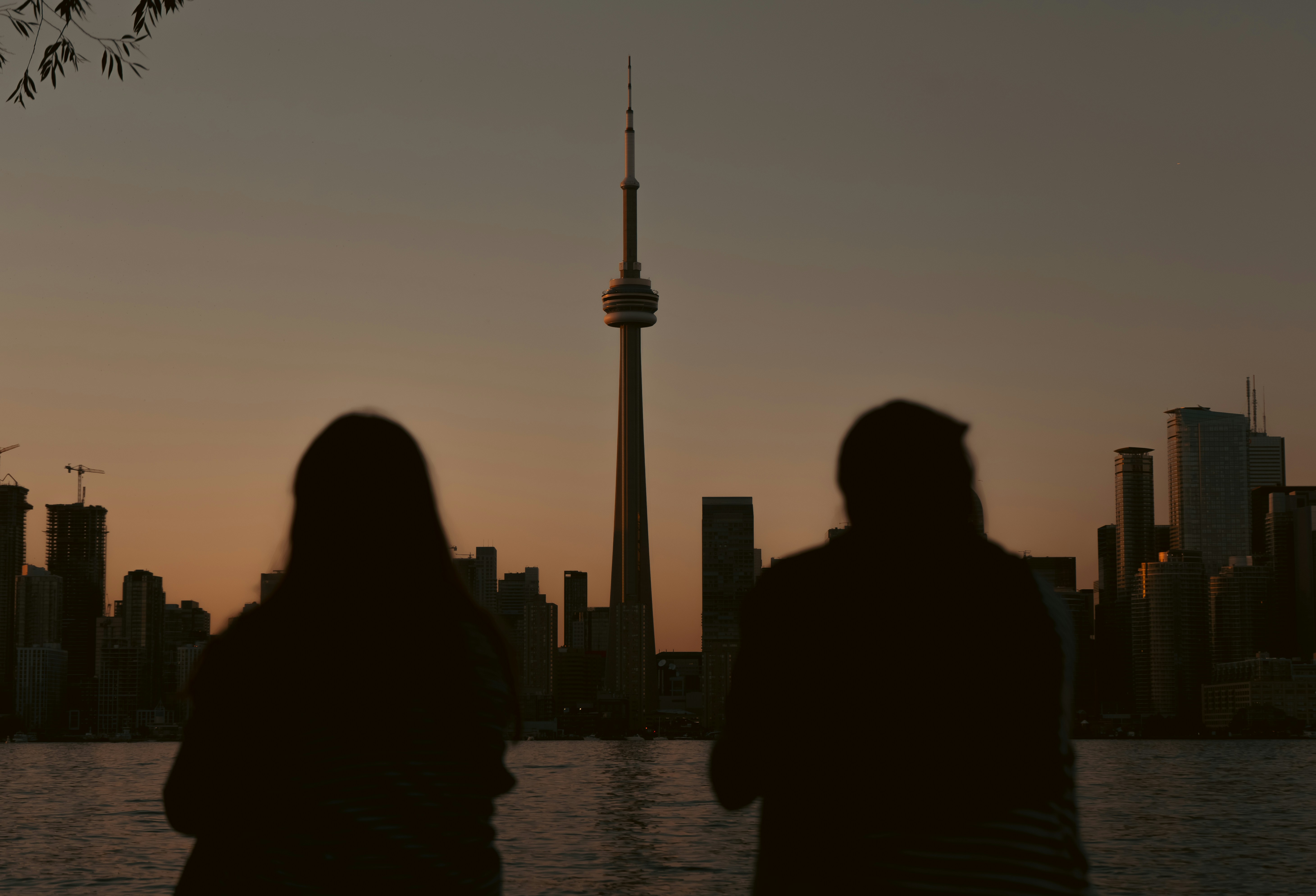 A couple of people standing next to each other near a body of water