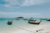 a group of boats sitting on top of a sandy beach