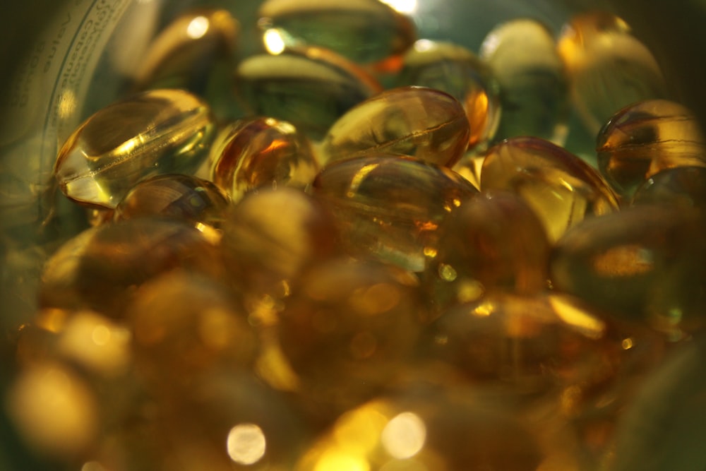 a glass bowl filled with lots of yellow and green pills