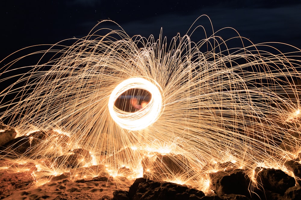 a firework spinning in the air over rocks